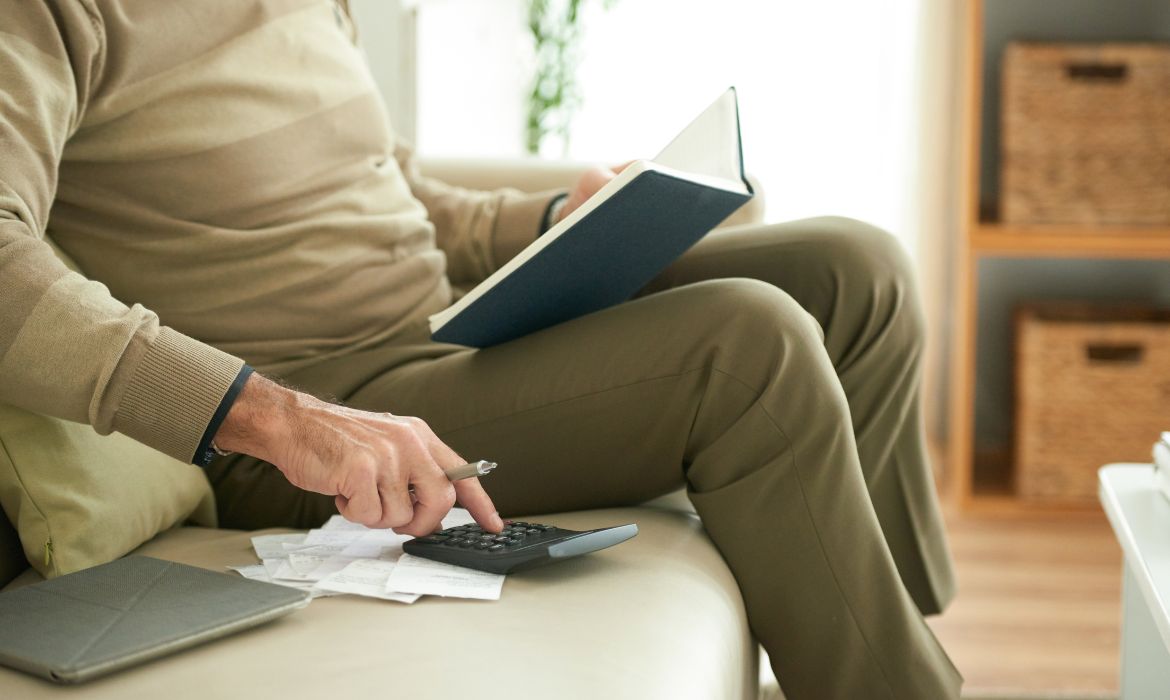 Anziano che fa i conti dell'IVA agevolata per dispositivi medici e ausili alla mobilità