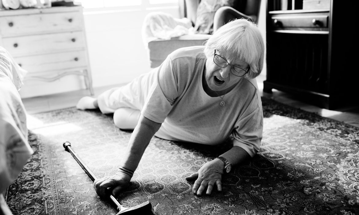 Donna anziana distesa sul pavimento durante un incidente casalingo. Ecco perchè prevenire cadute in casa è importante.